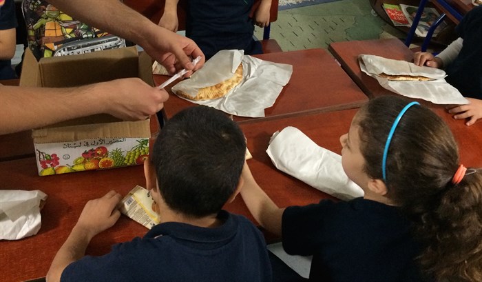 Refugee children receiving fresh, hot mana'eesh and fruit juice. They were excited! (Photo: Ashley al-Saliby)